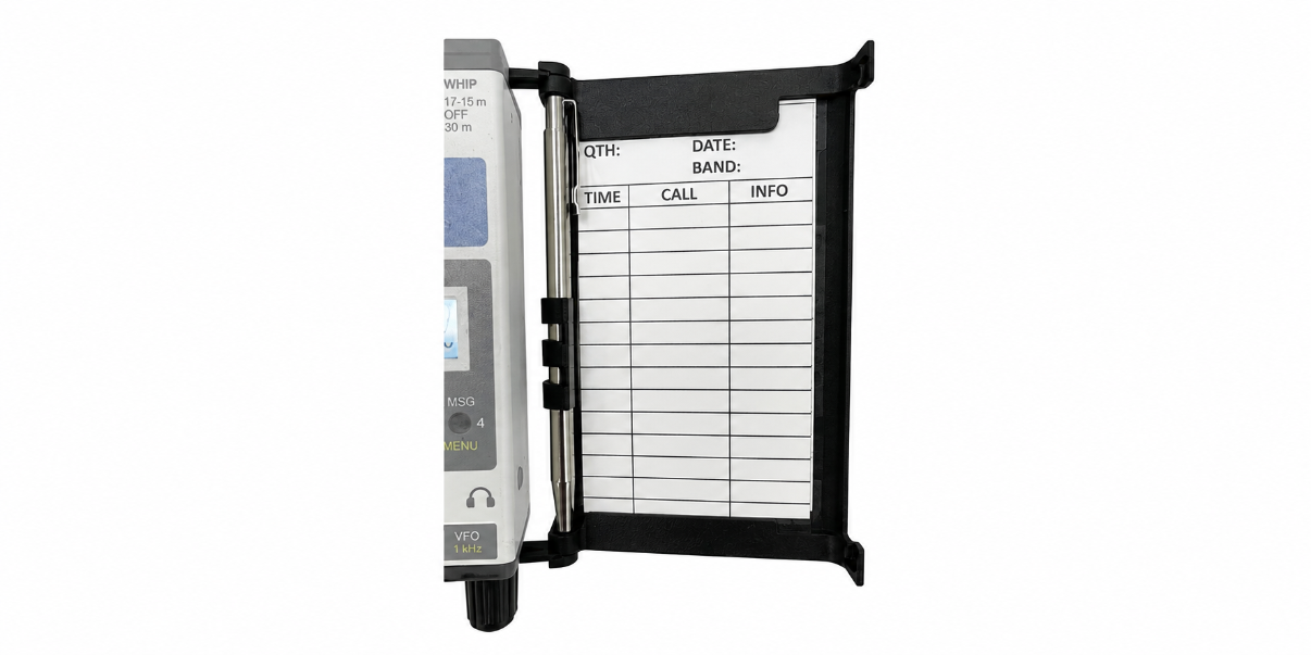 Open black logbook tray on KH1 transceiver, with lined log sheet and pen secured in side clip.